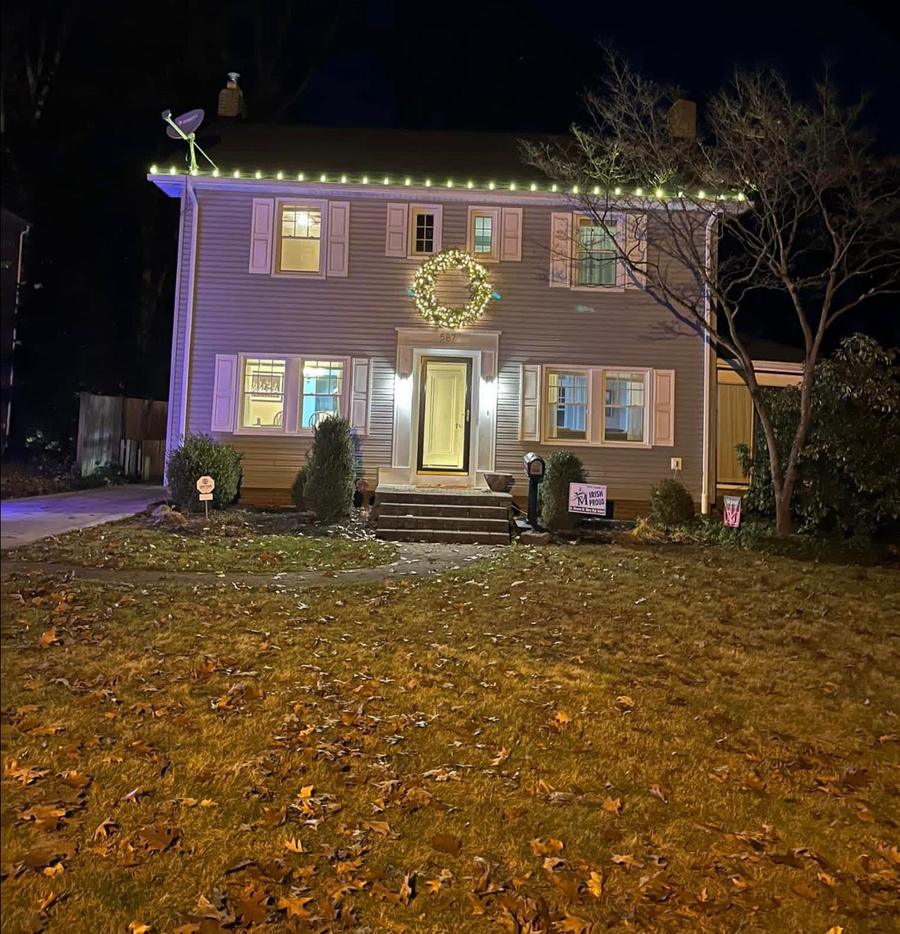 Colonial home with roofline lights and a window wreath