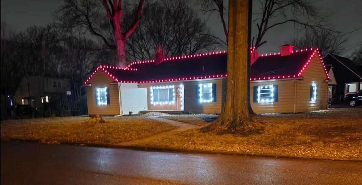 Ranch home with red roofline lights and lit windows