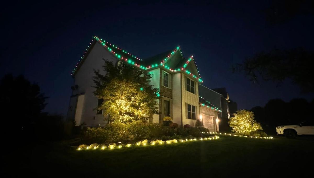 Home with green roofline lights and lit landscaping